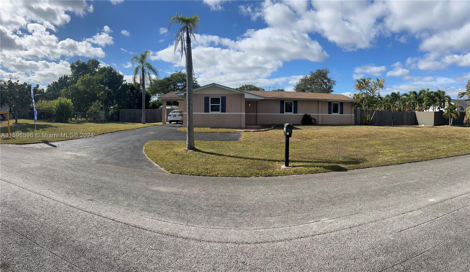 a view of a house with a big yard and a large tree