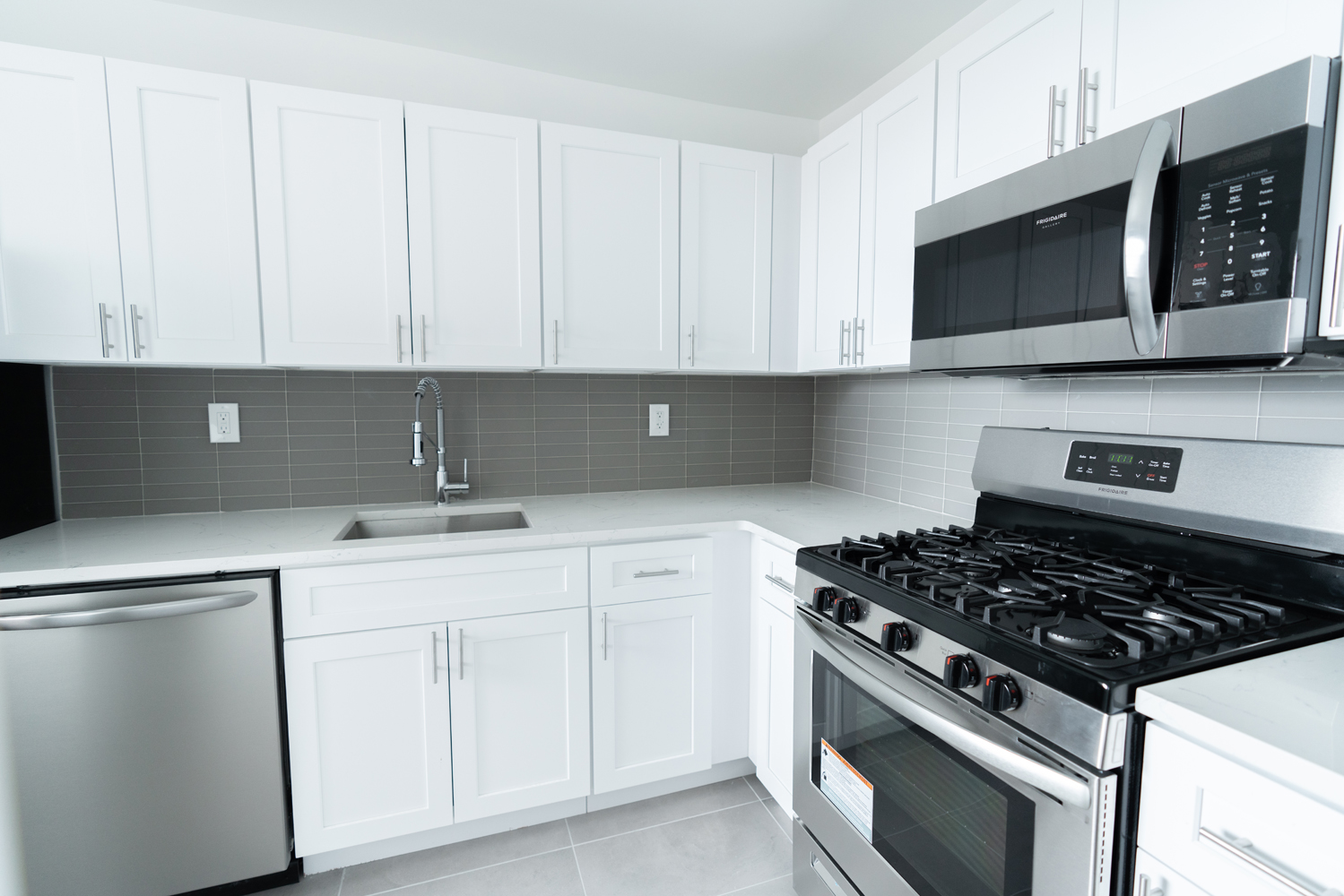 a kitchen with white cabinets and black appliances