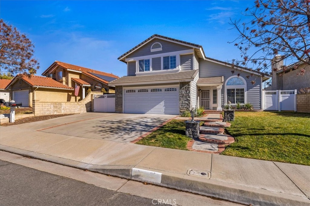 Front of House with wide driveway and gated RV parking.