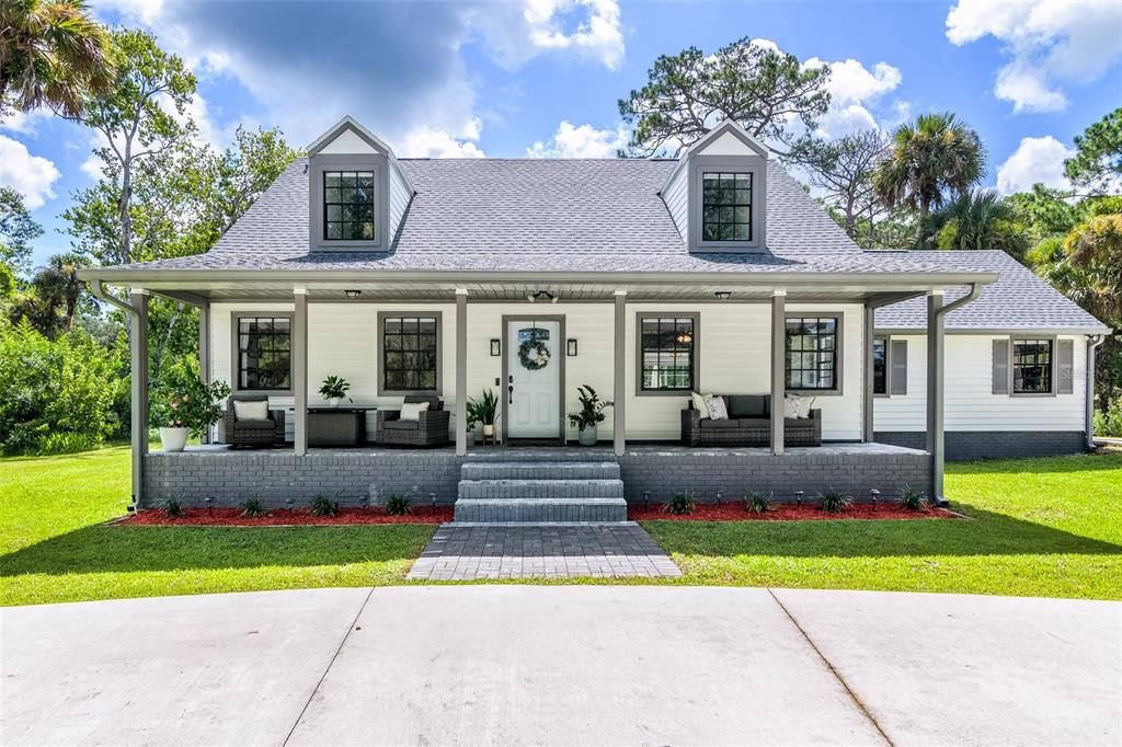 a front view of house with yard and outdoor seating