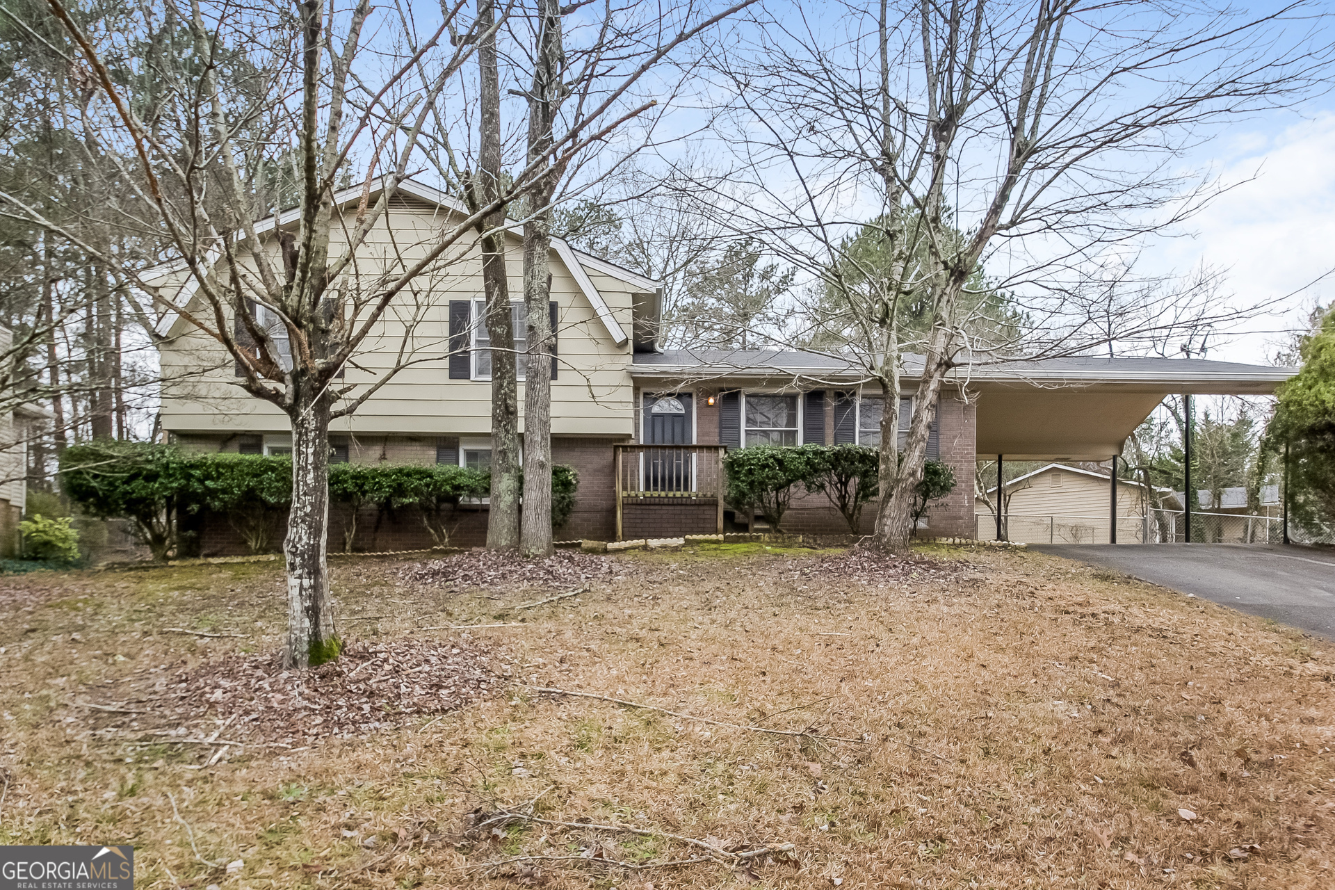 a view of a house with a yard and large tree