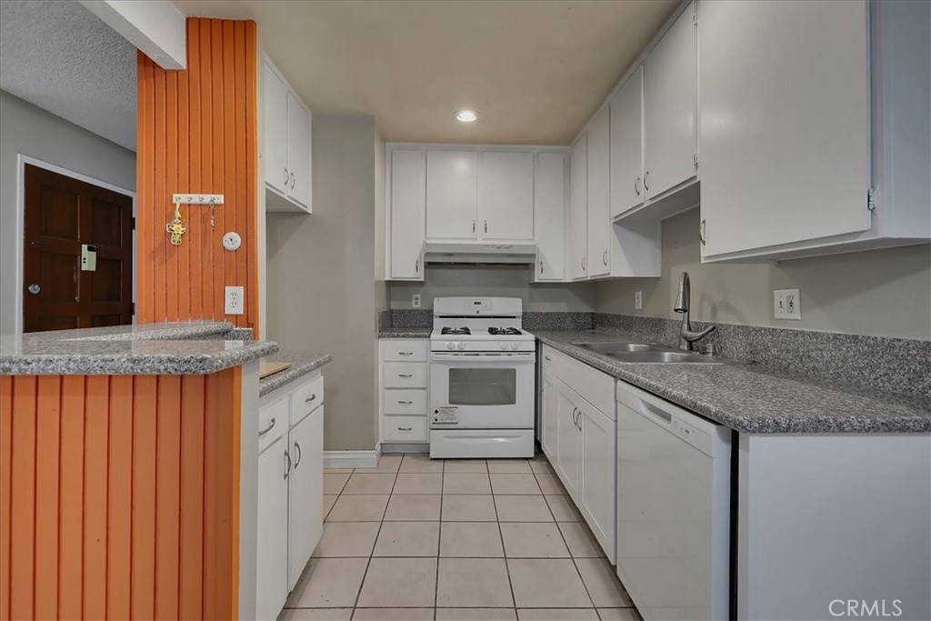 a kitchen with granite countertop a sink stove and cabinets