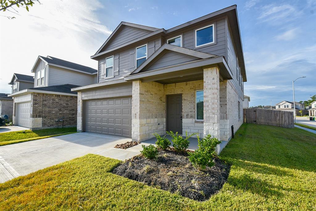 Modern two-story home with a mix of brick and siding exterior, featuring a two-car garage.