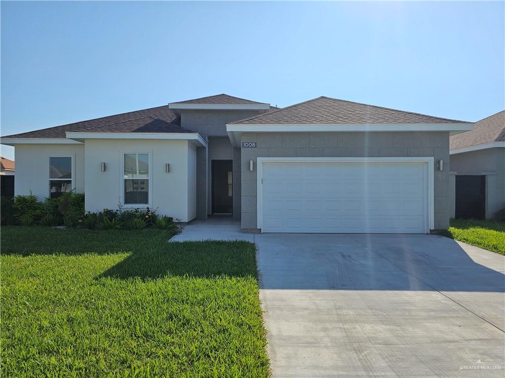 View of front of house featuring a front yard and a garage