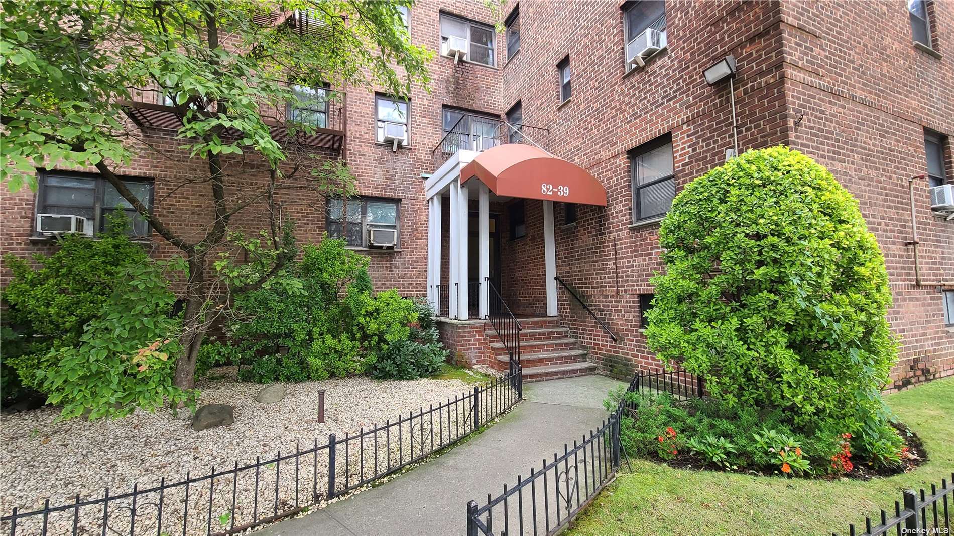 a front view of a multi story building with a yard