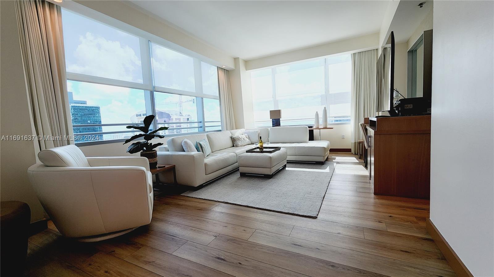 a living room with furniture windows and a flat screen tv