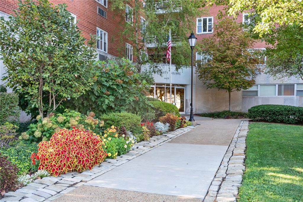 a front view of a house with a yard and fountain