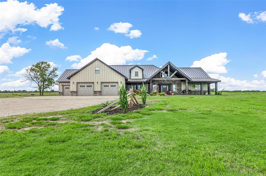 a view of a house with a big yard and large trees