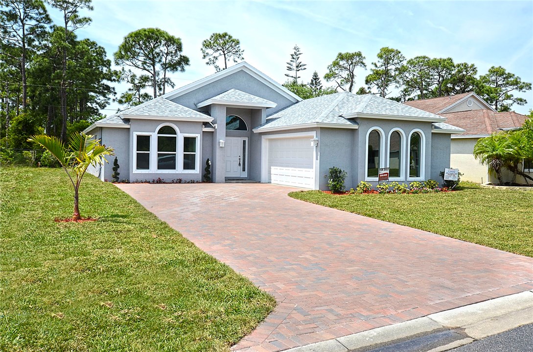 a front view of a house with a yard and trees