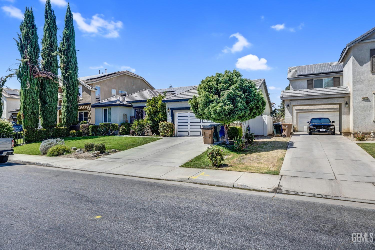 a front view of a house with a yard and potted plants