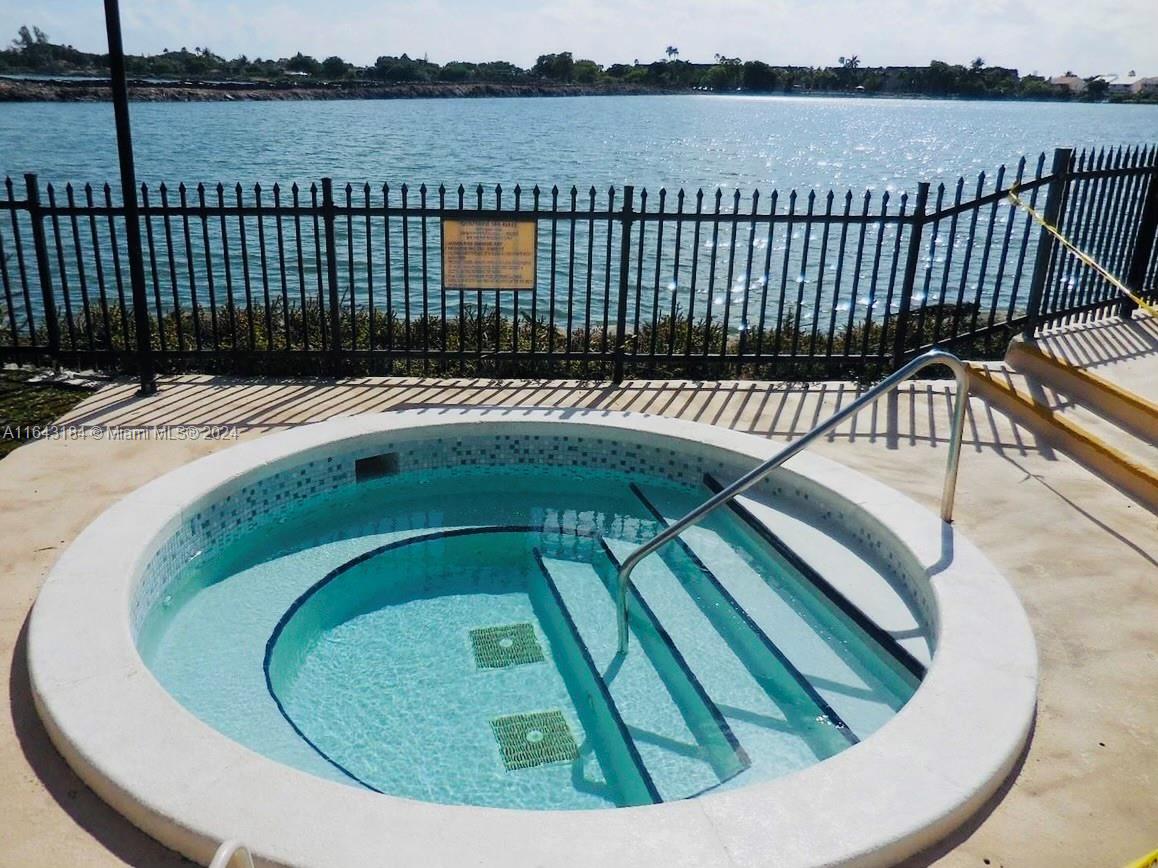 a view of swimming pool with outdoor seating and lake