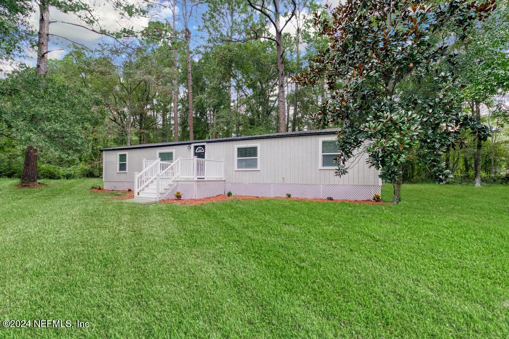 a view of a house with backyard and garden