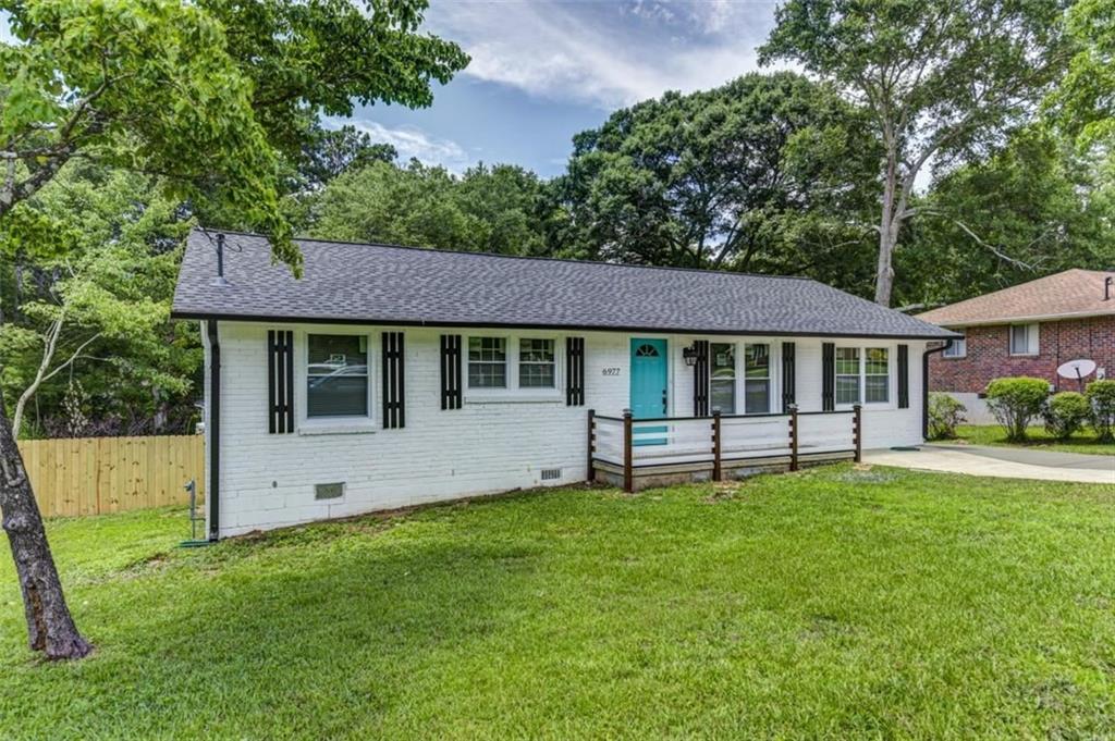 a view of a house with a yard and sitting area