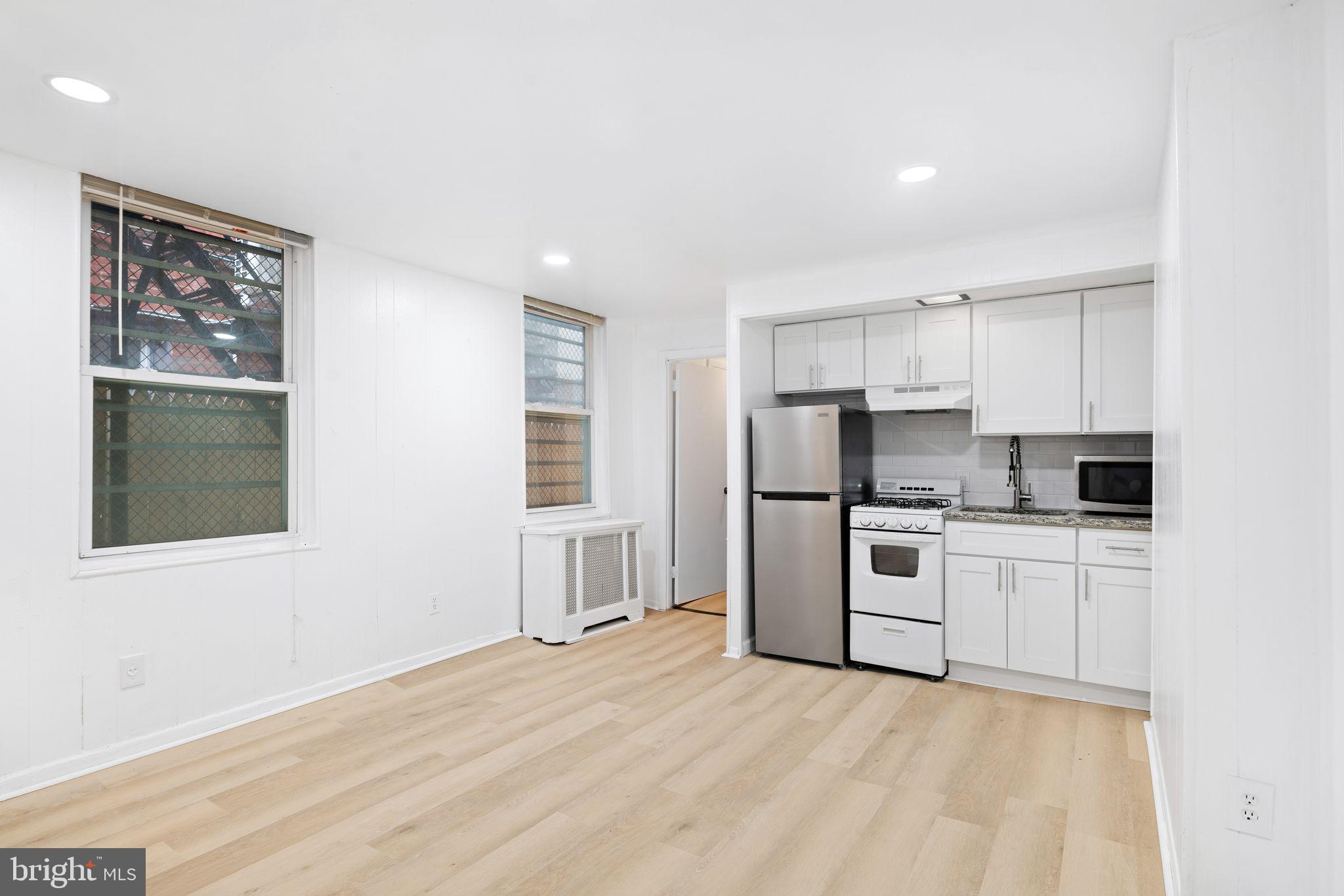 a kitchen with white cabinets and stainless steel appliances