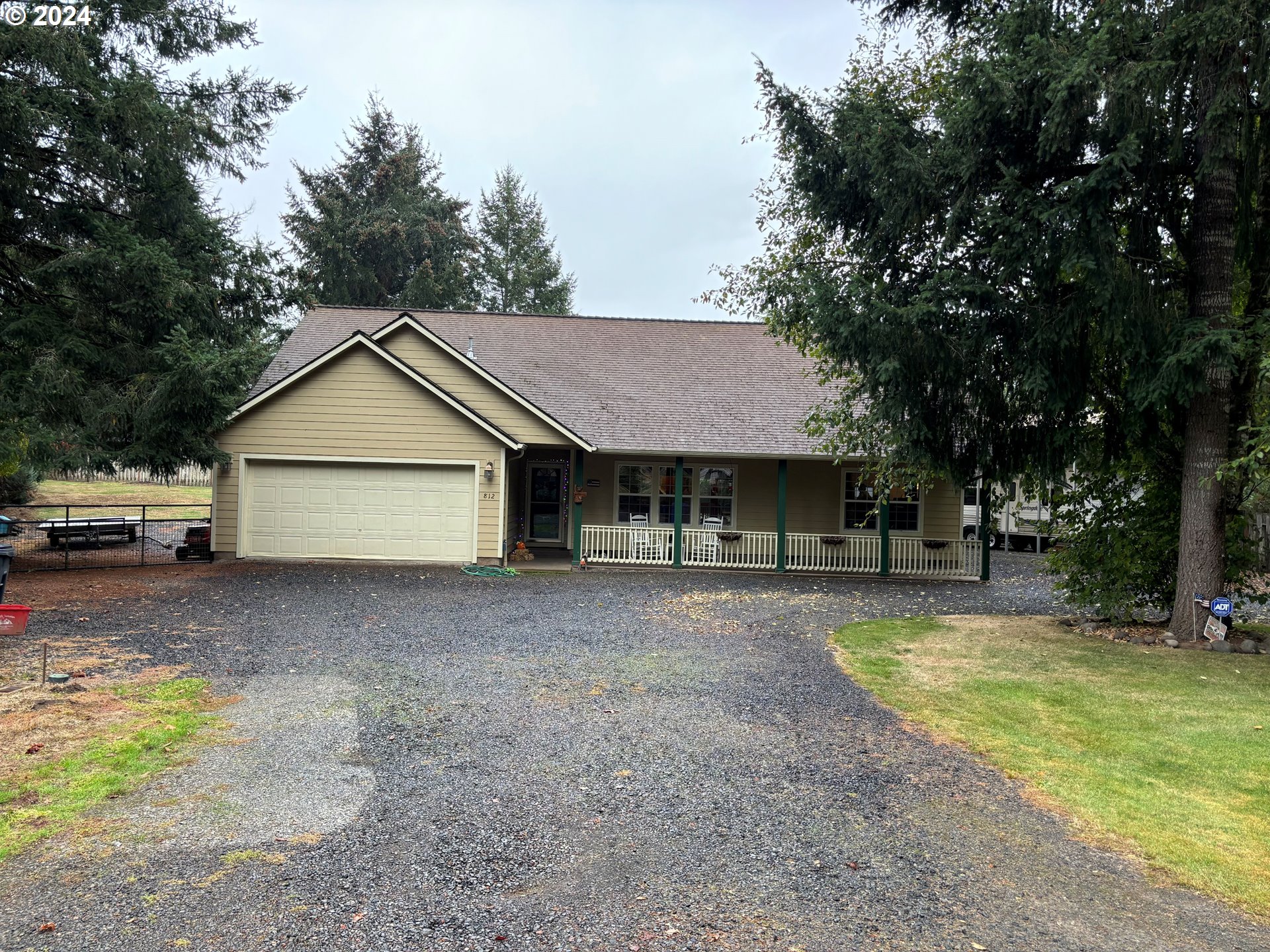 a view of a house with a yard and large tree