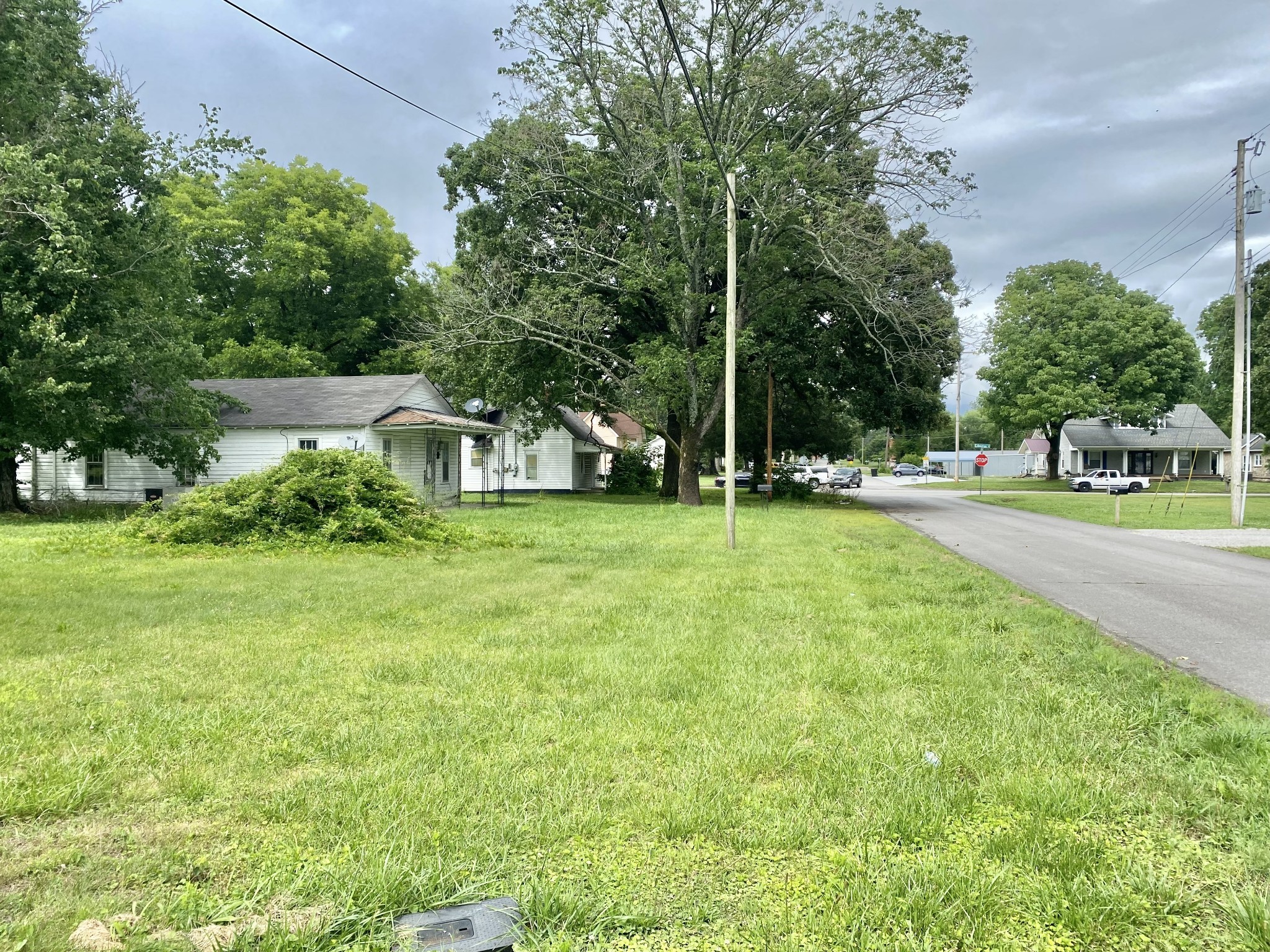 a view of a house with a big yard and large trees