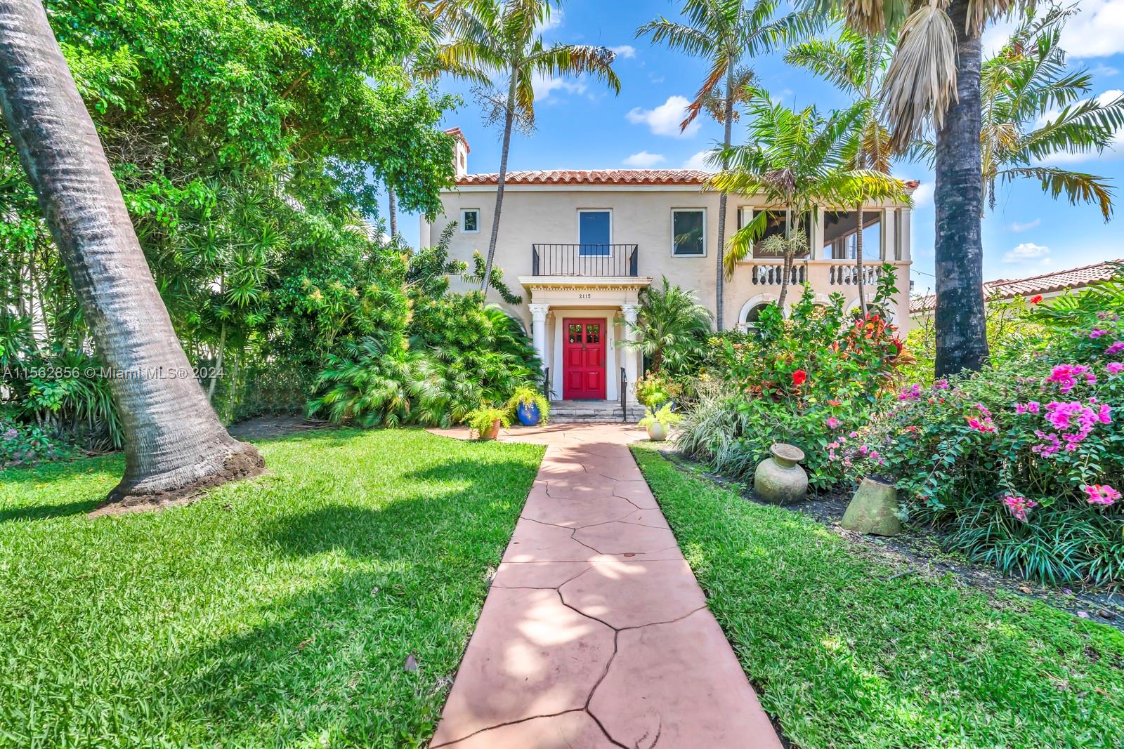 a front view of a house with a yard and potted plants