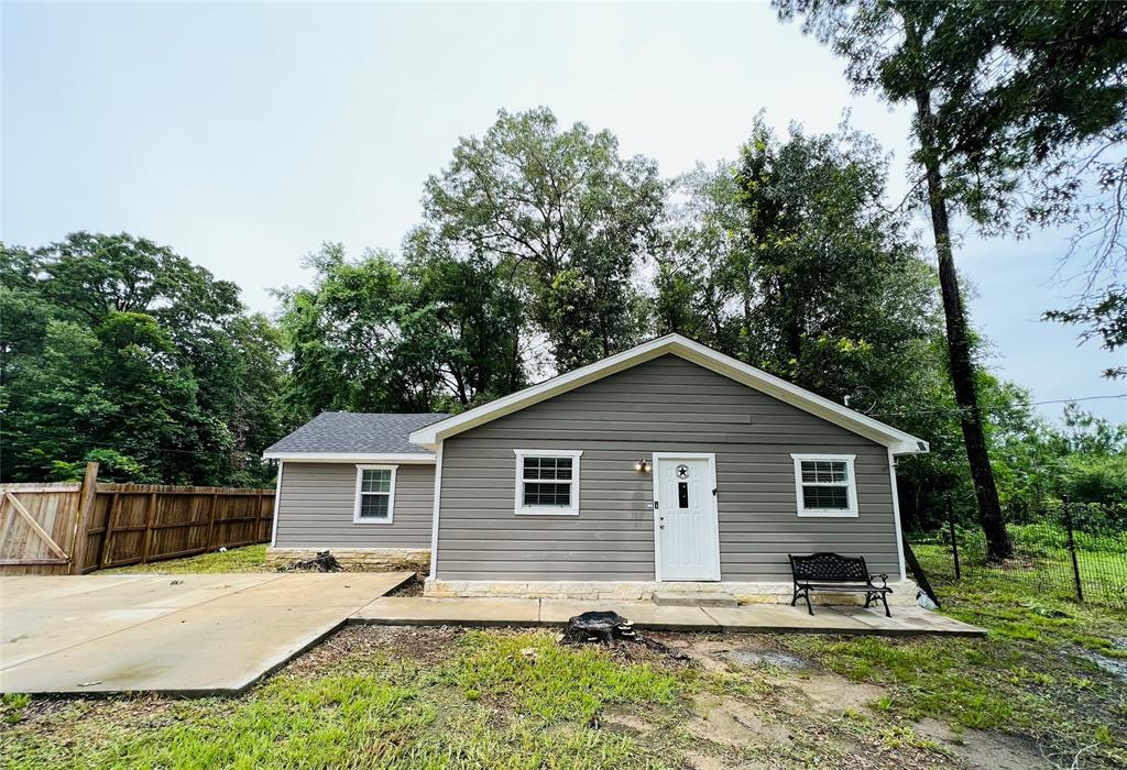 a front view of house with yard and trees in the background