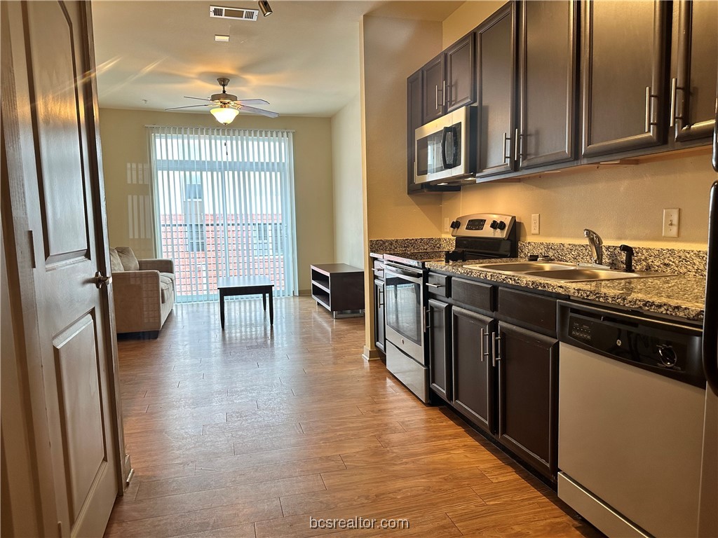 a kitchen with stainless steel appliances granite countertop a sink stove and refrigerator