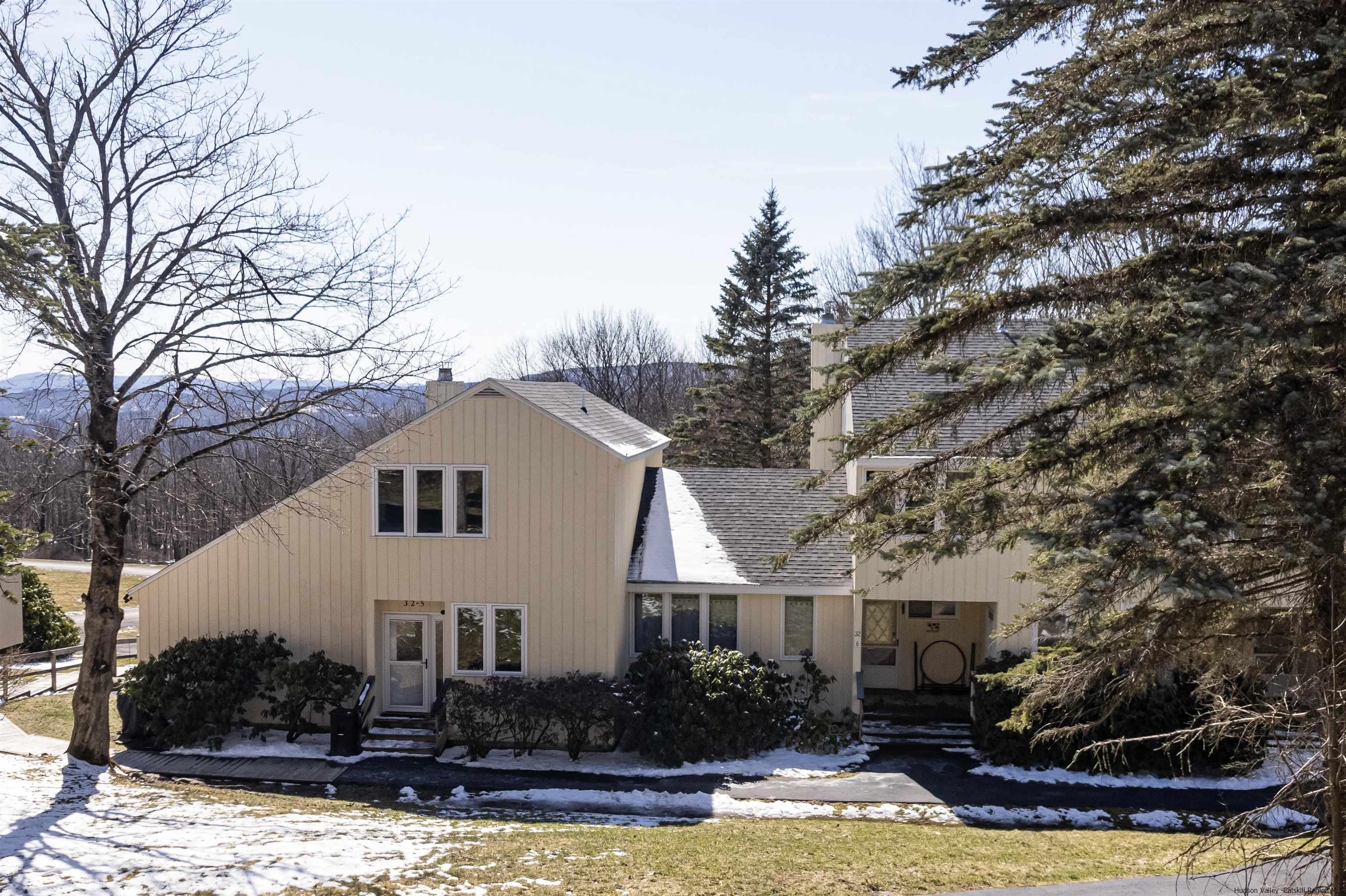 a front view of a house with a yard covered with snow