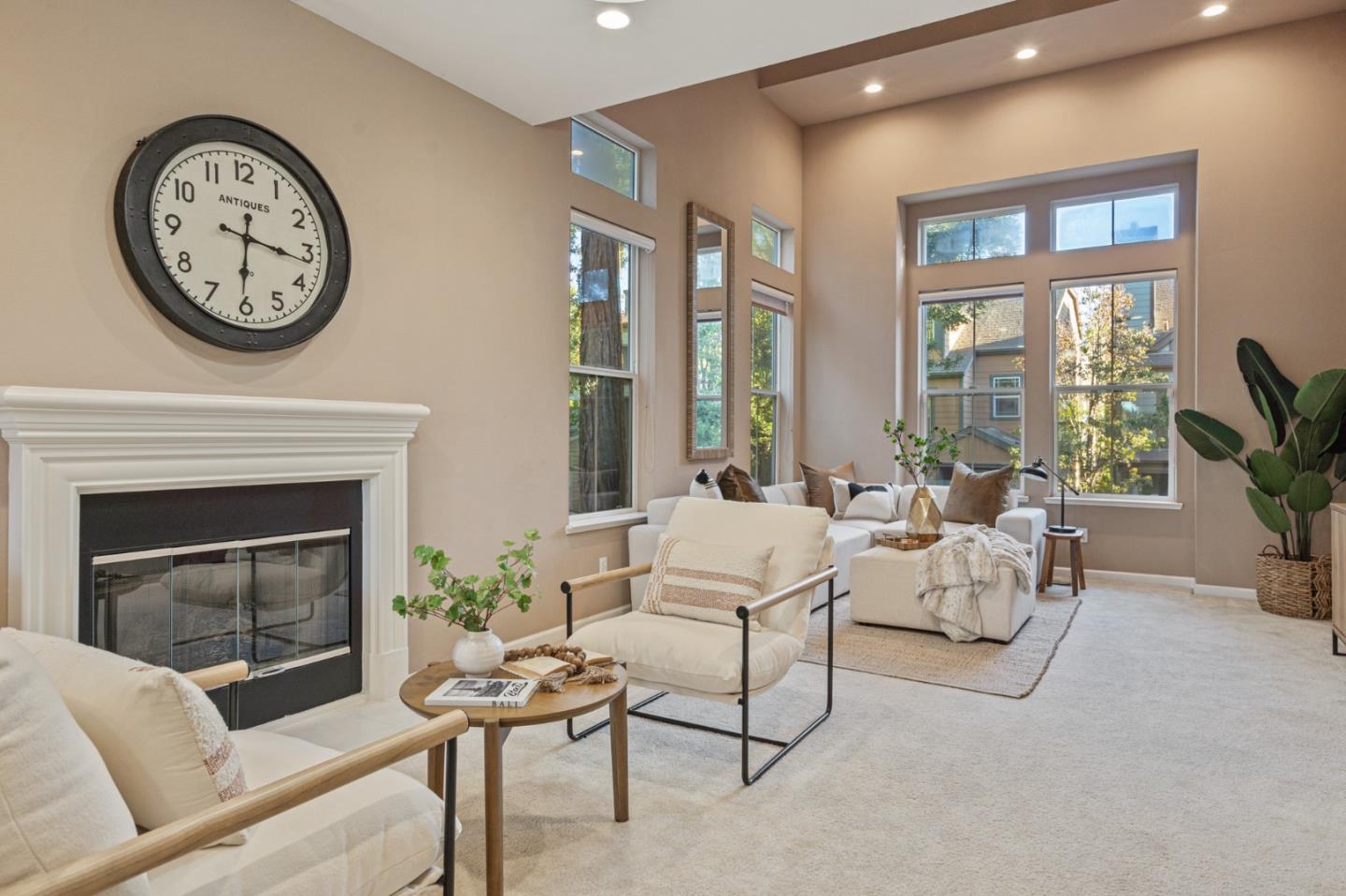 a living room with furniture a large window and a clock