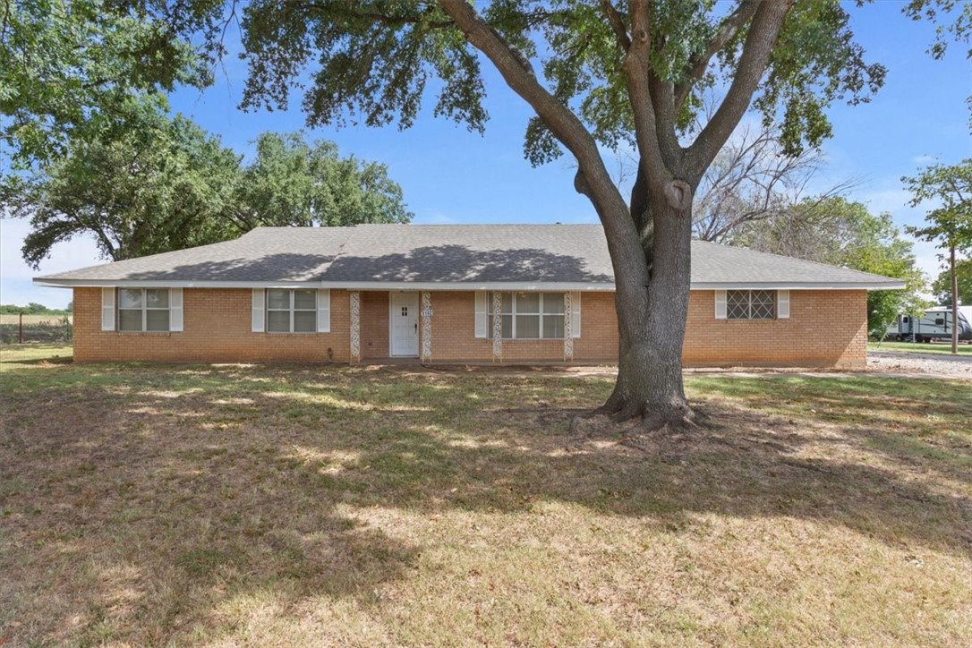 a front view of a house with a tree