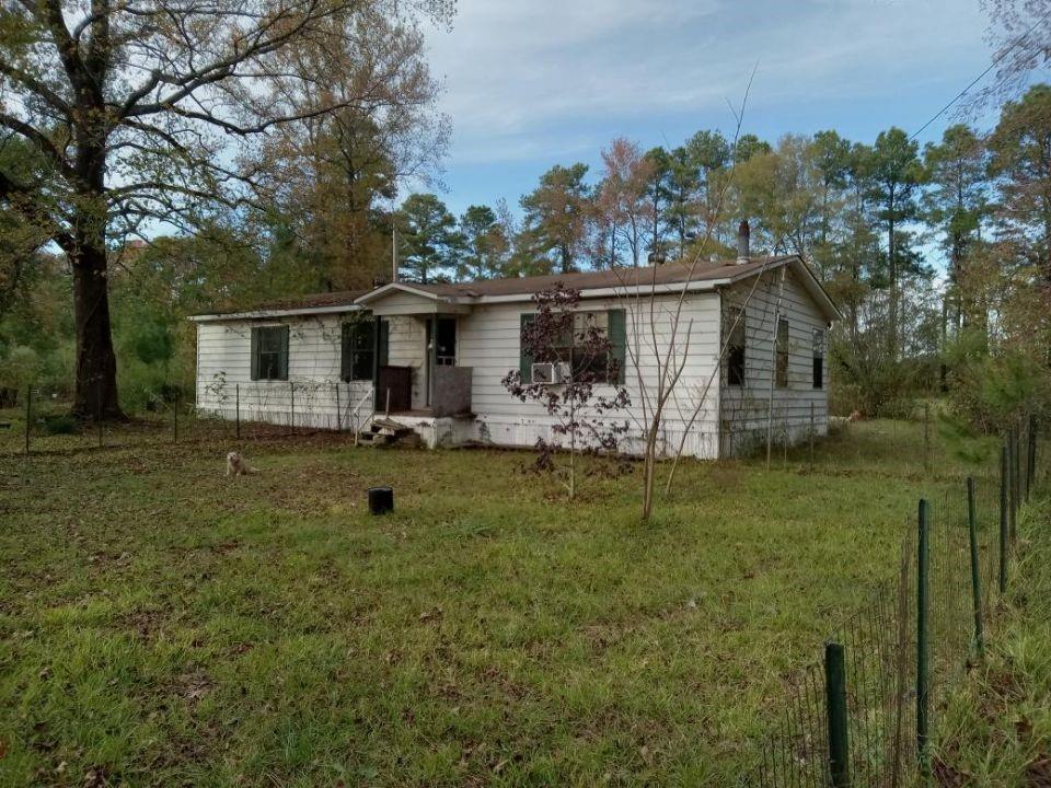 a view of a house with backyard and a tree