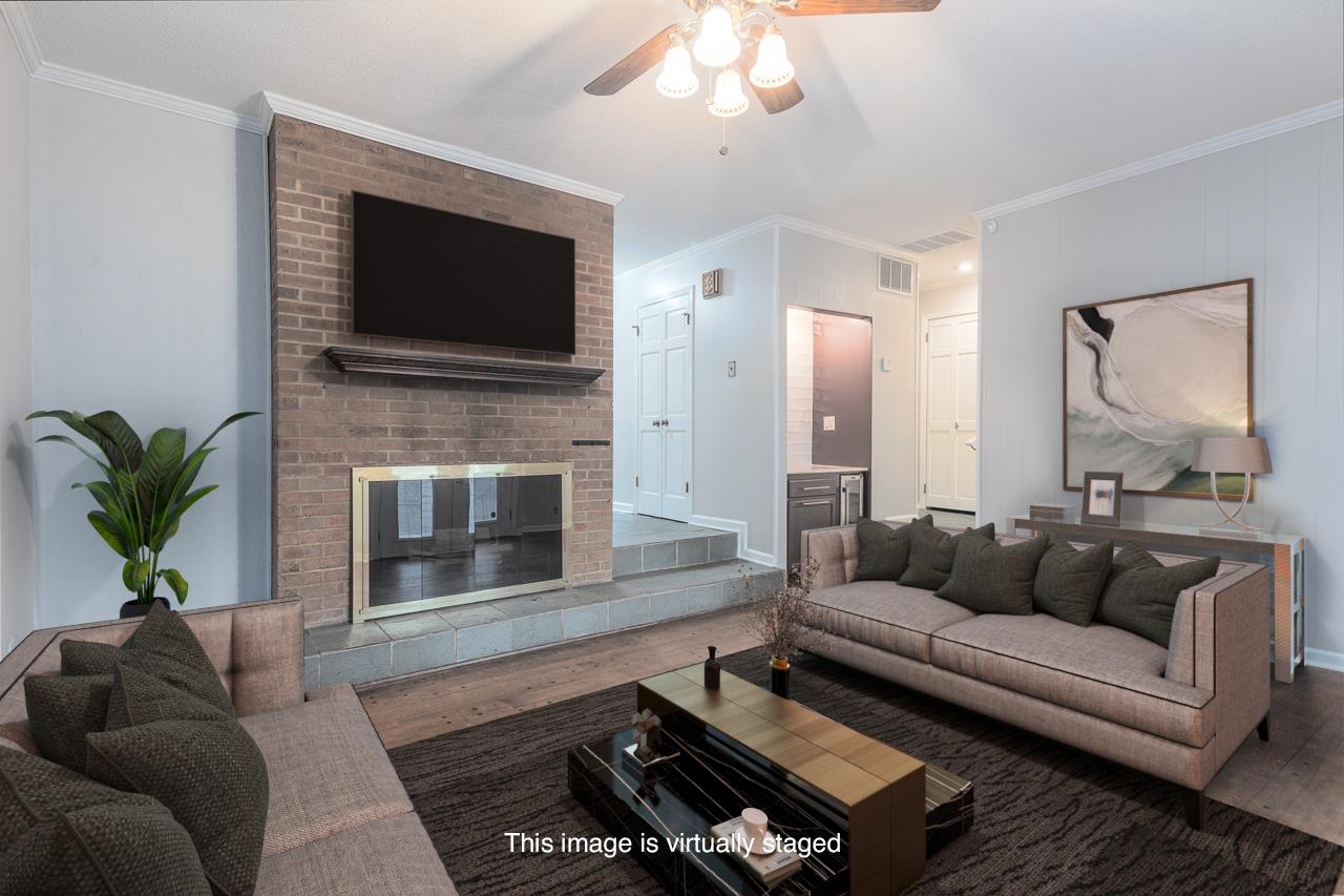 a living room with furniture a flat screen tv and a fireplace