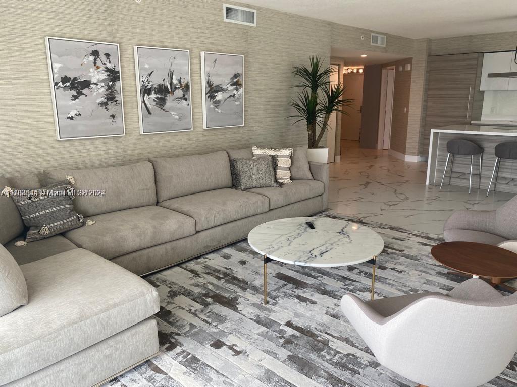 a living room with furniture a couch and potted plant