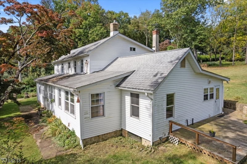 a view of house with a yard and large tree