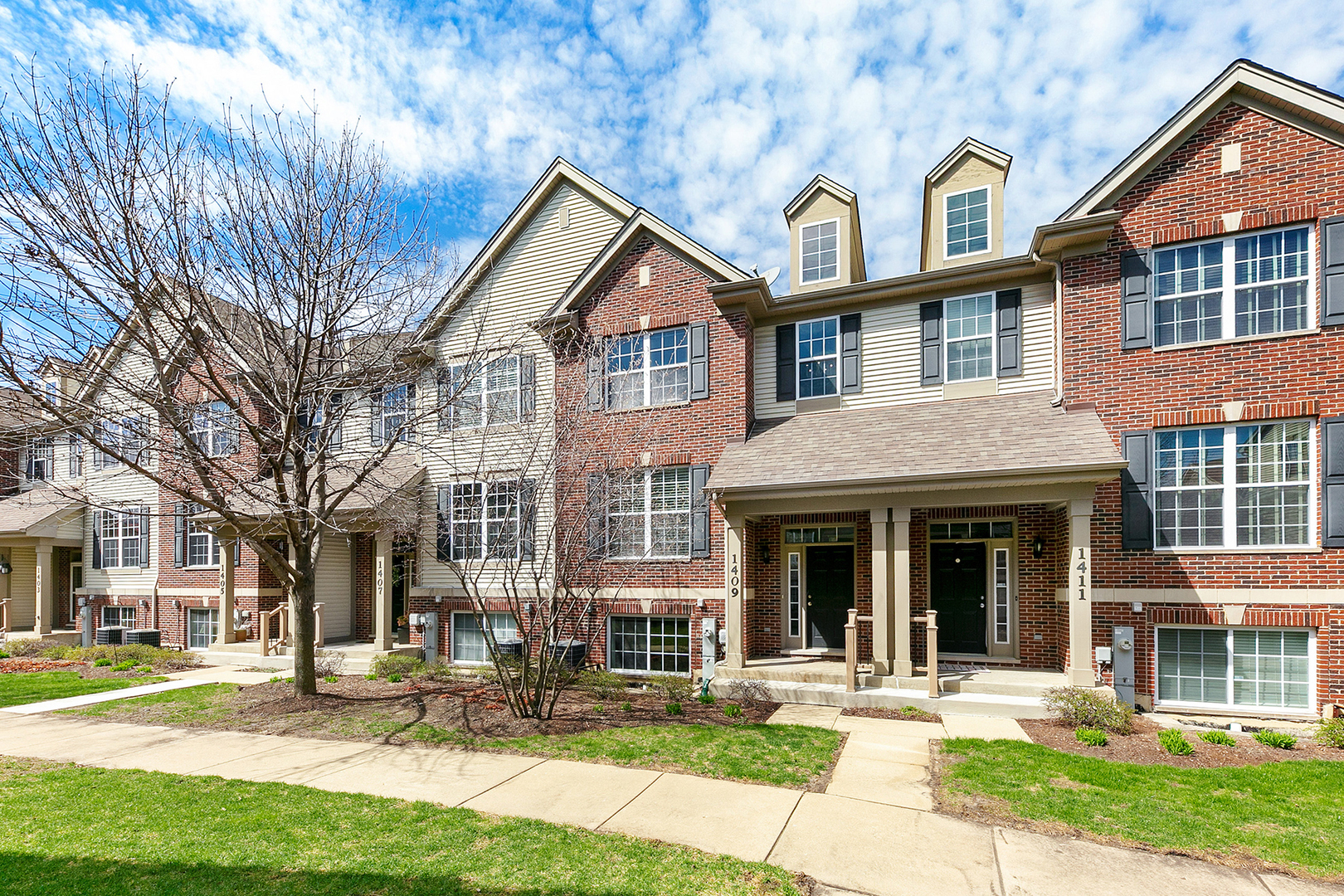 a front view of a residential apartment building with a yard