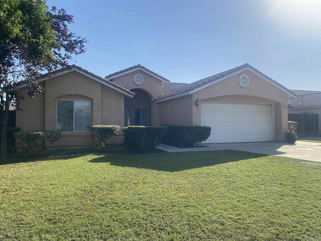 a front view of house with yard and garage