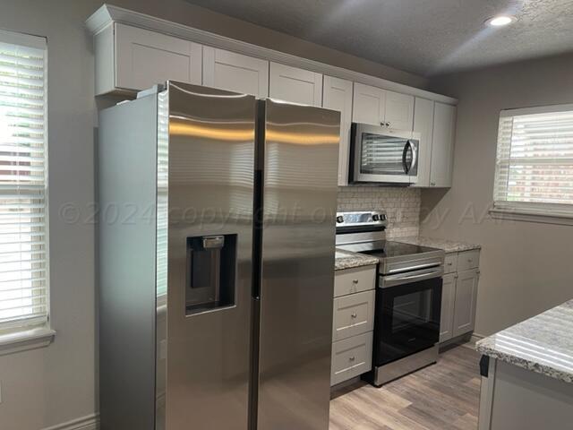 a kitchen with stainless steel appliances granite countertop a refrigerator and a stove