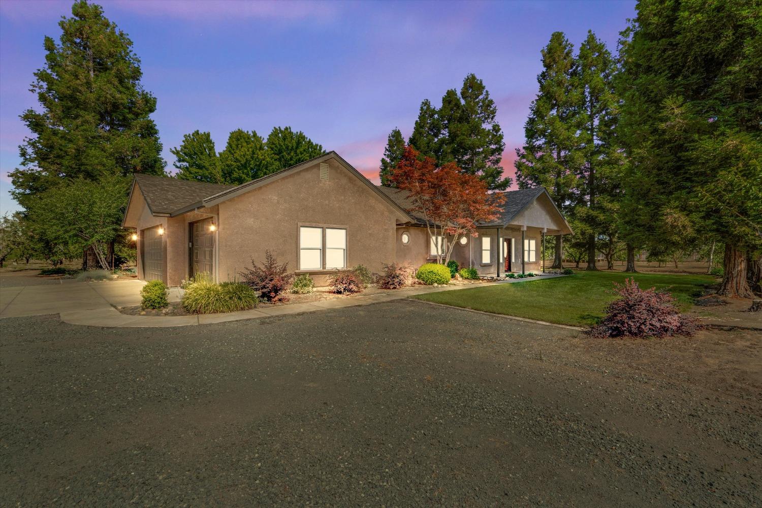 a front view of a house with a yard and tree s