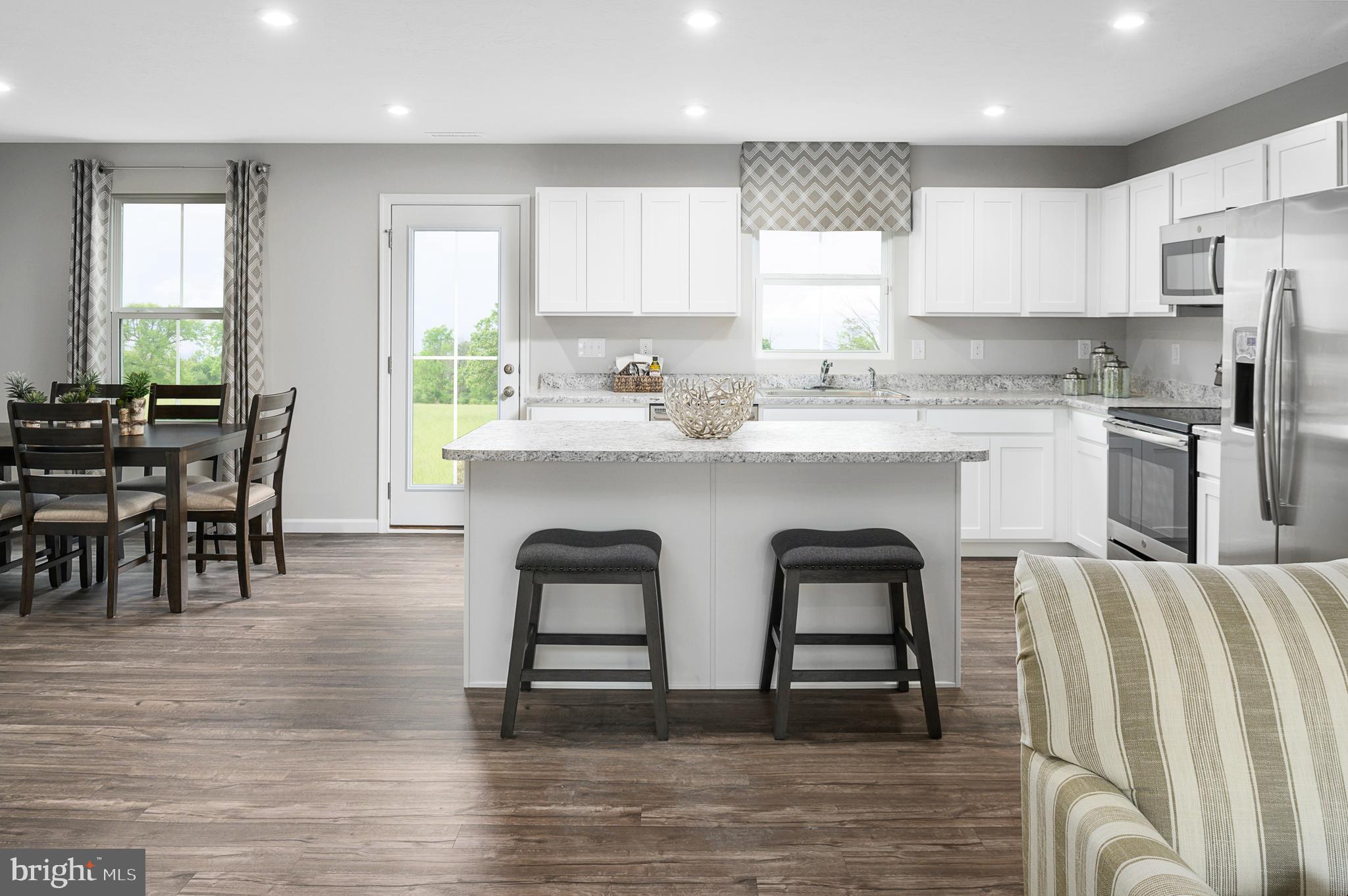 a kitchen with stainless steel appliances granite countertop a table and chairs in it