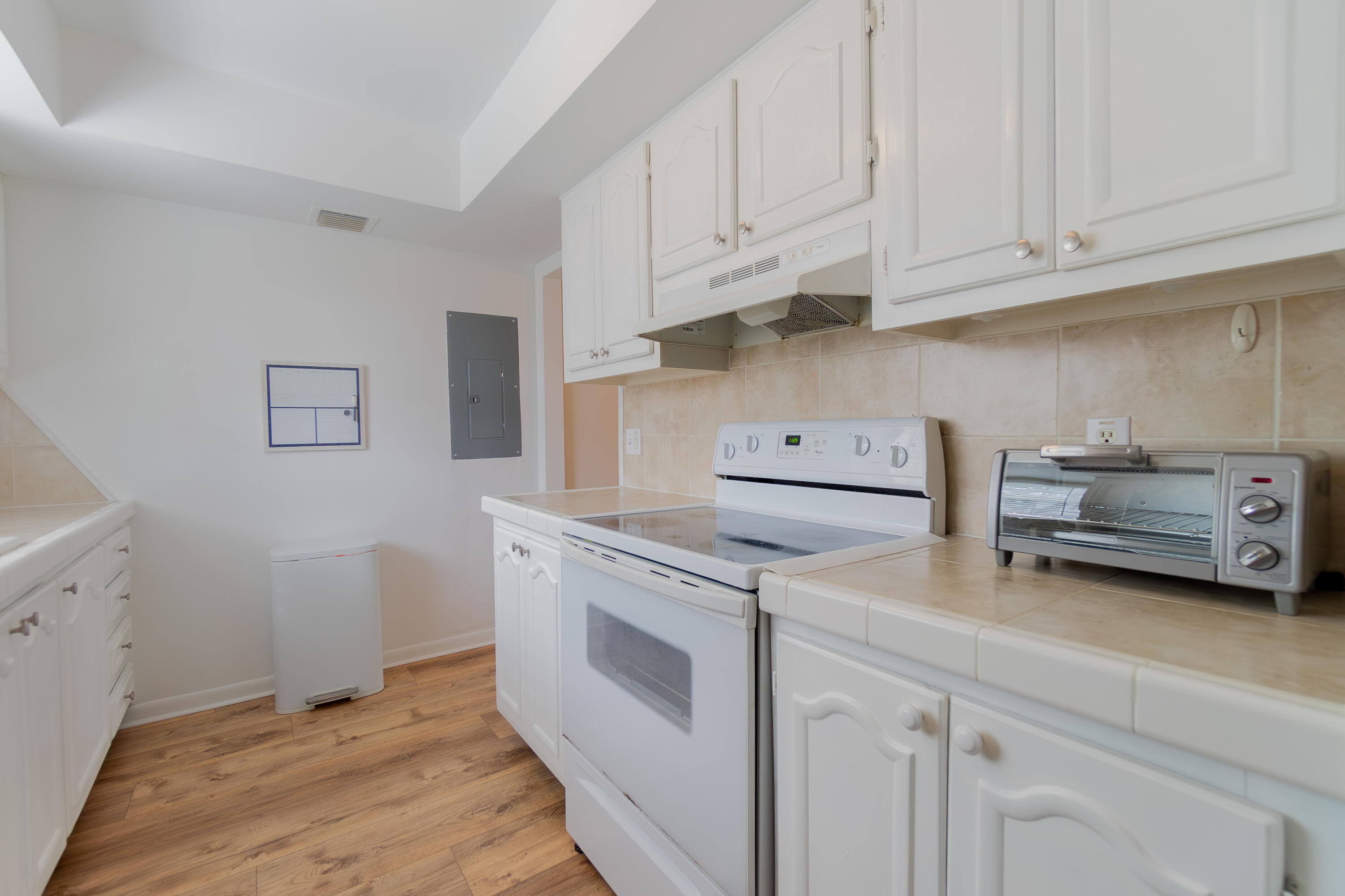 a kitchen with stainless steel appliances granite countertop a sink a stove and white cabinets