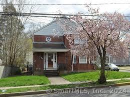 a view of a brick house with a large windows and a large tree