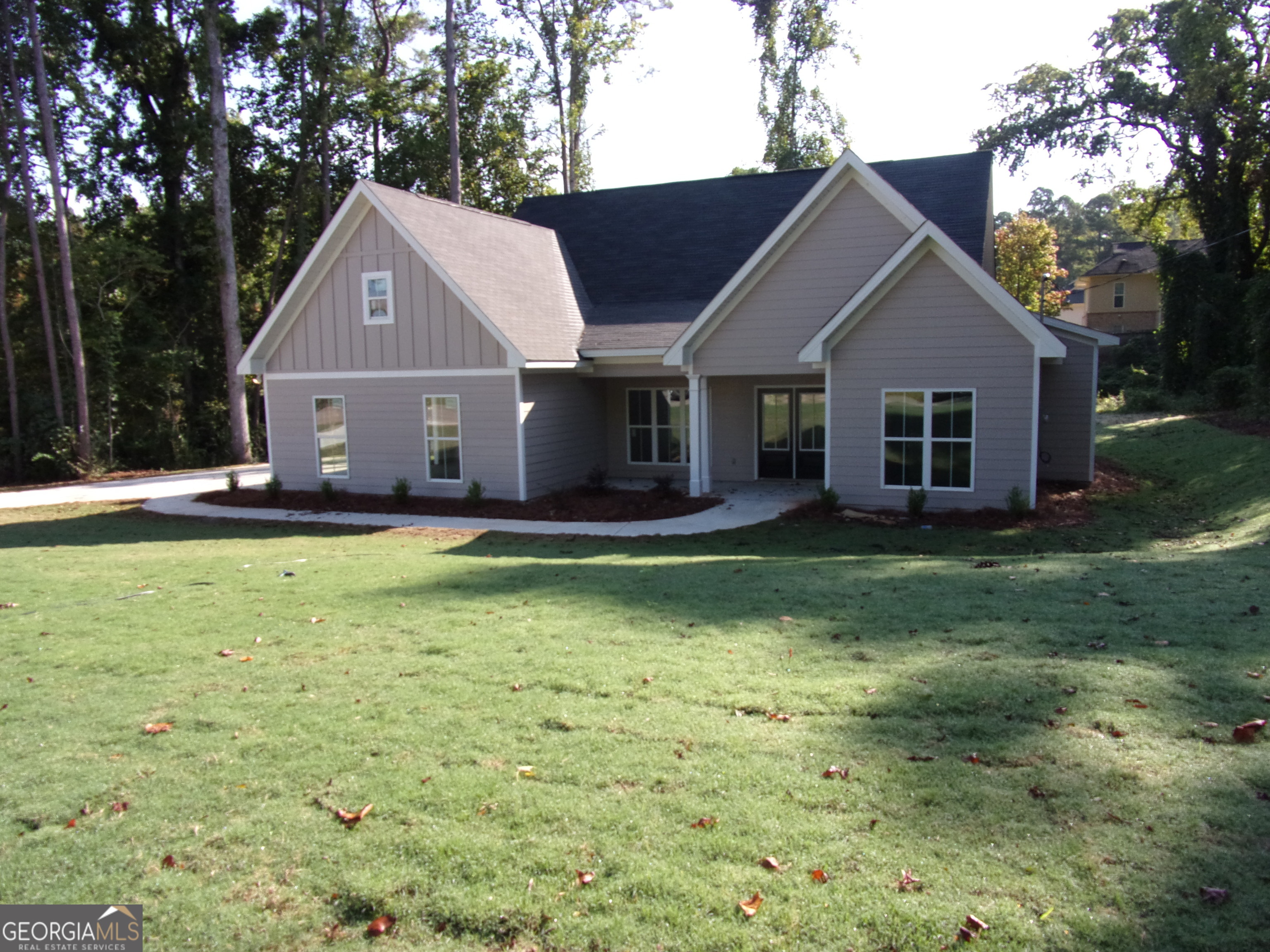 a front view of house with yard and trees in the background