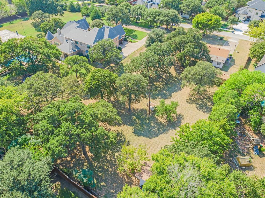 an aerial view of residential house with outdoor space and trees all around