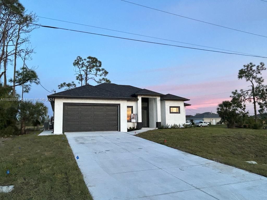 a front view of a house with a yard and garage