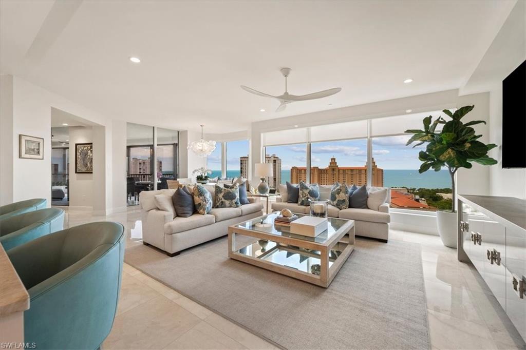 a living room with furniture kitchen view and a large window