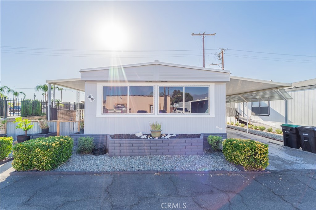 a front view of a house with a yard and potted plants