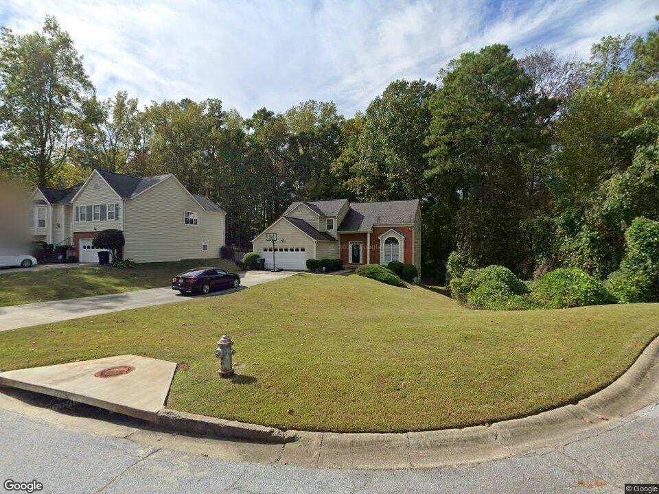 a view of a house with pool and trees in the background