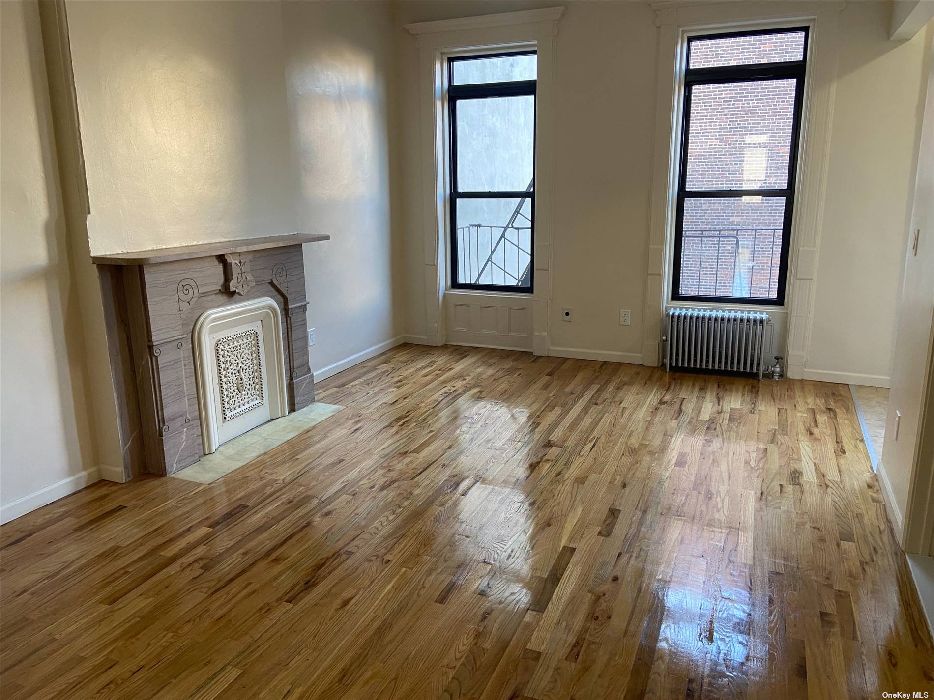 a view of a hallway with wooden floor and a fireplace