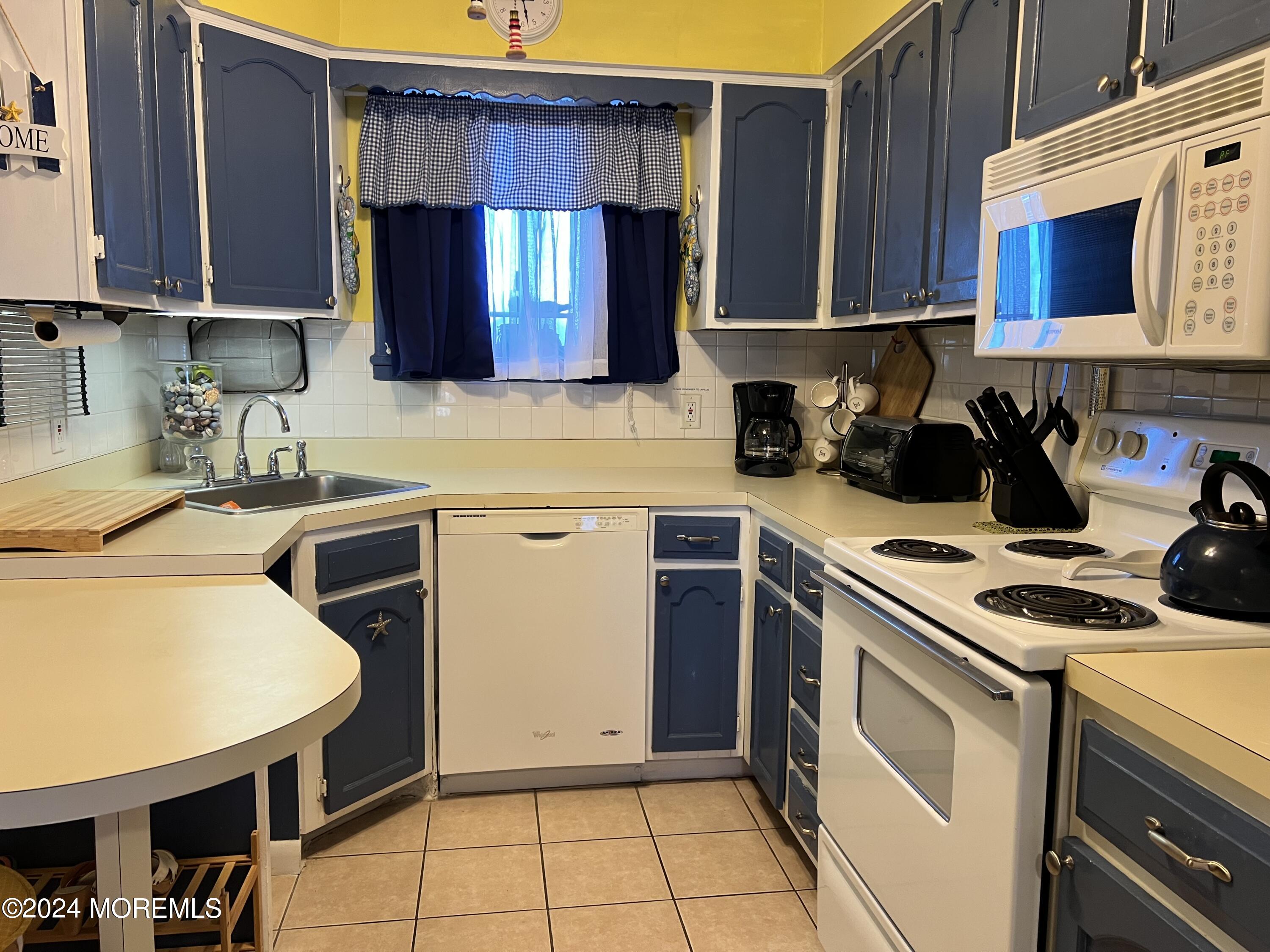 a kitchen with a sink a stove and cabinets