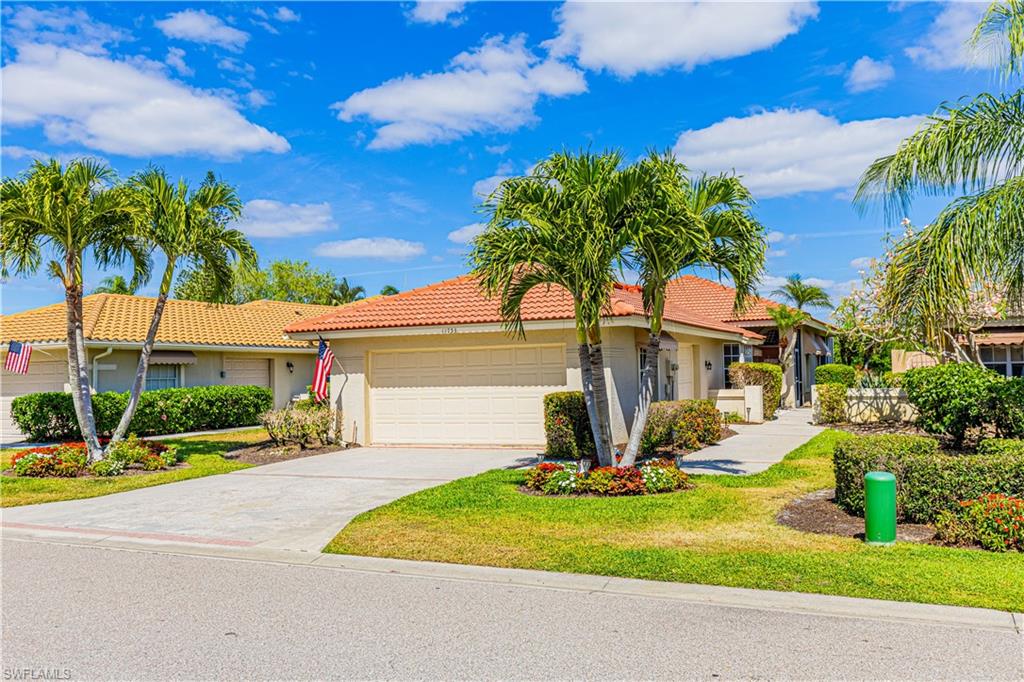 a view of a house with palm trees and a small yard