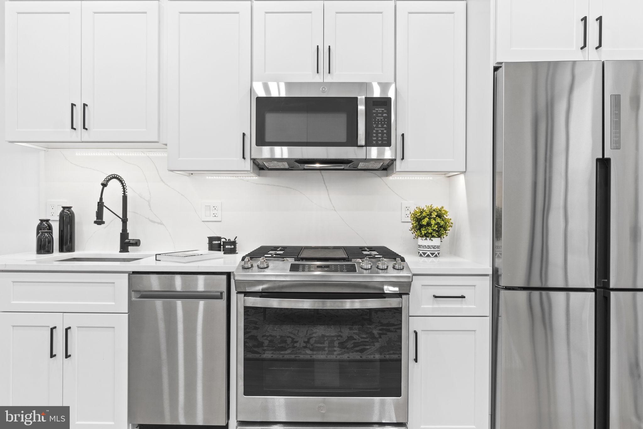 a kitchen with stainless steel appliances a stove a refrigerator and a sink