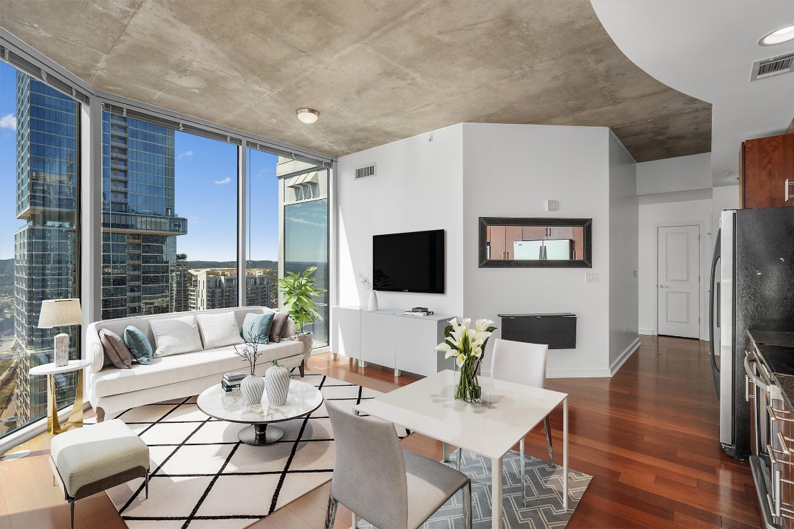 Open concept living space with plenty of room for a sectional and eating area with phenomenal panoramic views of Lady Bird Lake and downtown. *virtually staged