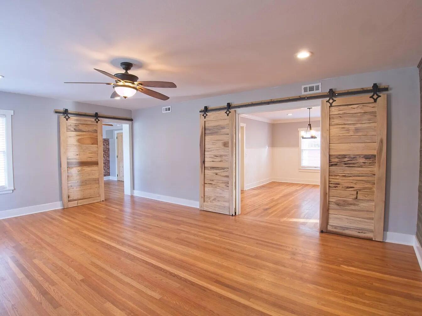 a view of empty room with wooden floor and ceiling fan