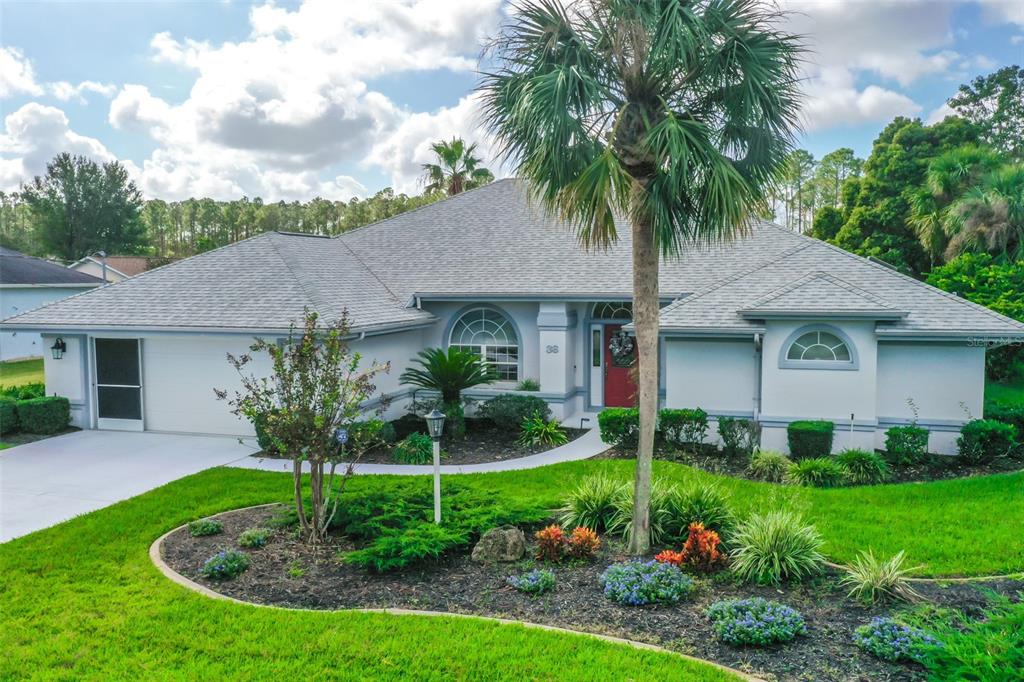 a front view of a house with a yard and potted plants